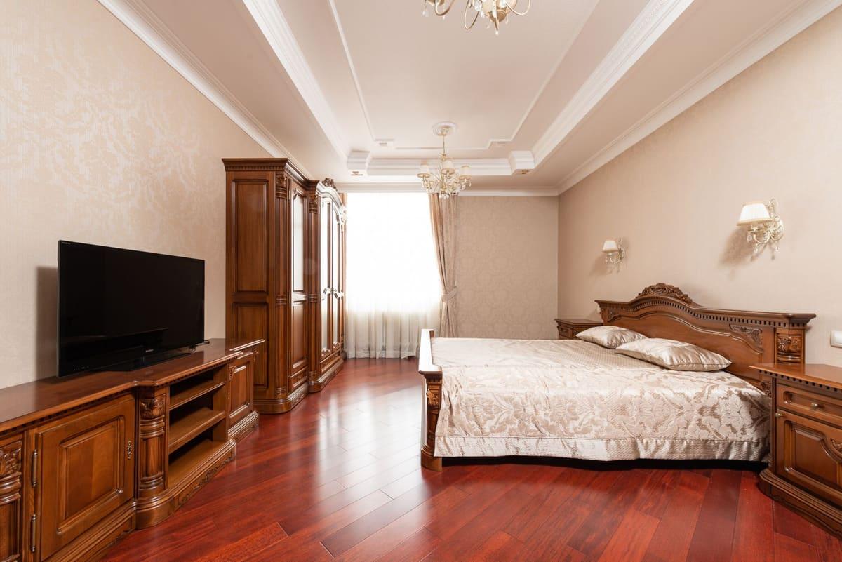 Luxurious classic bedroom with ornate furniture and natural lighting.