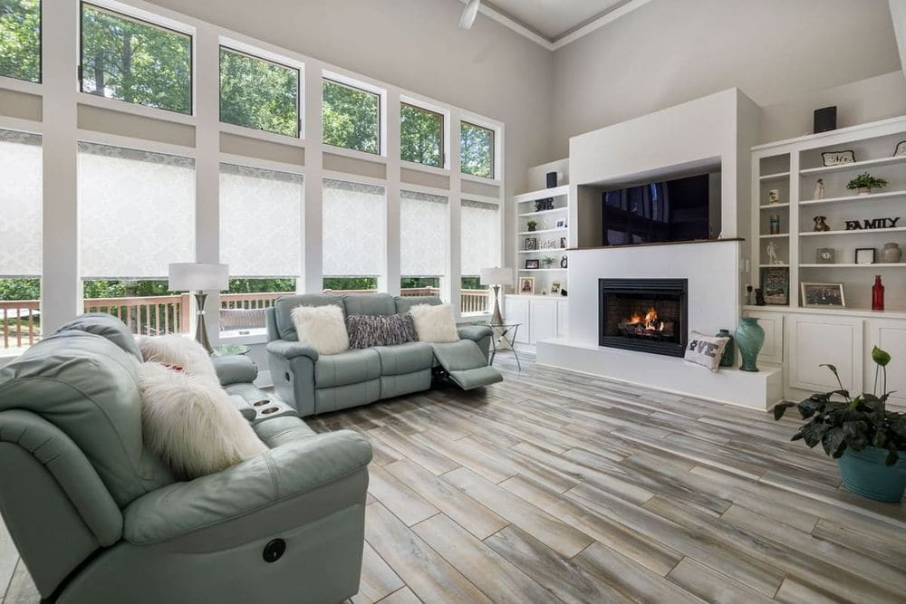 Bright and spacious living room with fireplace, large windows, and stylish furniture.