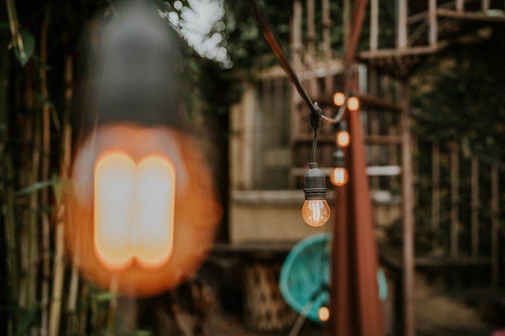 Edison bulb string lights creating a cozy outdoor ambiance with rustic charm.