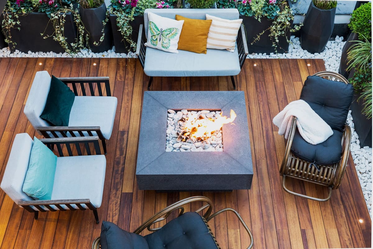 A top-down view of a modern patio featuring stylish furniture and a central firepit.