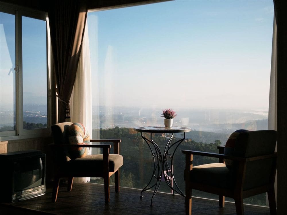 Cozy indoor seating with mountain view through large windows, perfect for relaxation.
