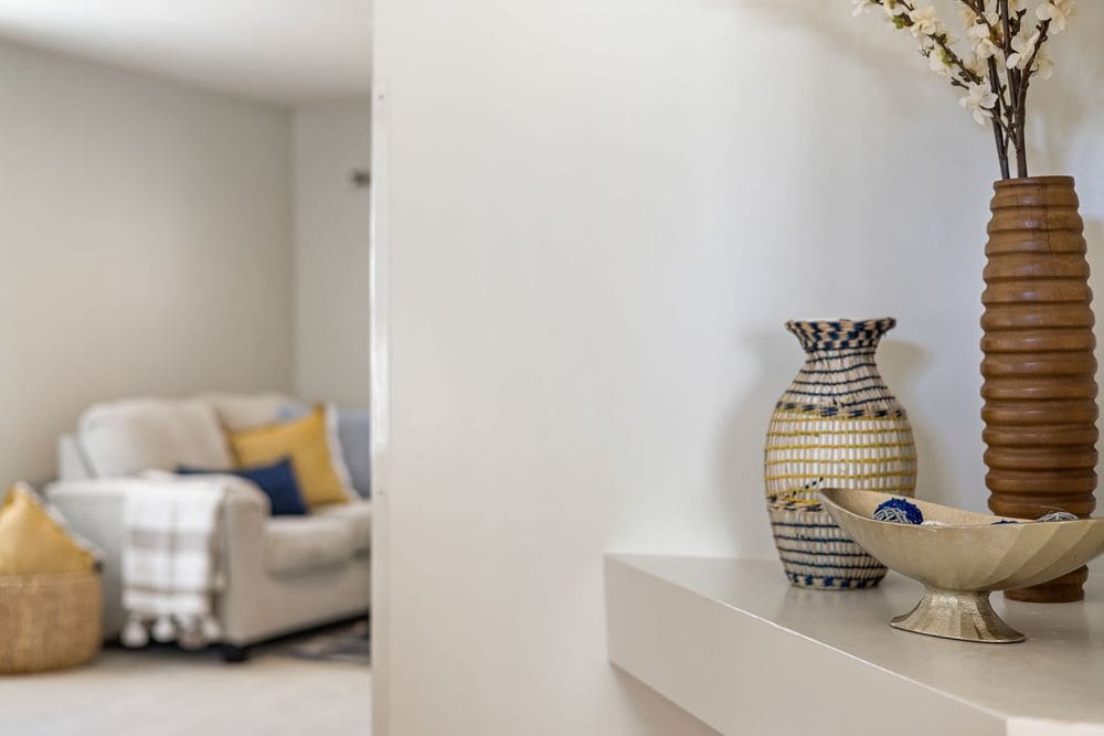 Stylish home interior featuring decorative vases on a shelf with a cozy couch in the background.