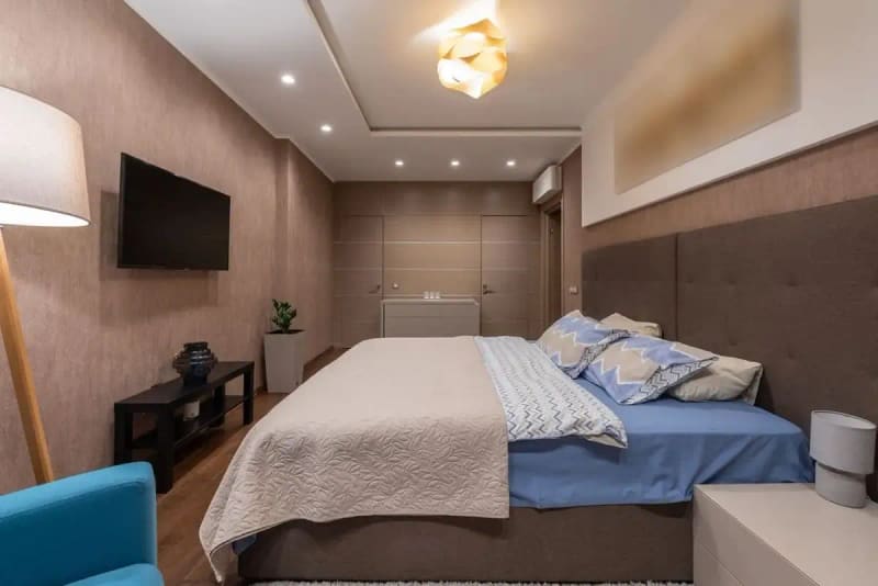 Elegant modern bedroom featuring a stylish bed, ambient lighting, and cozy decor.
