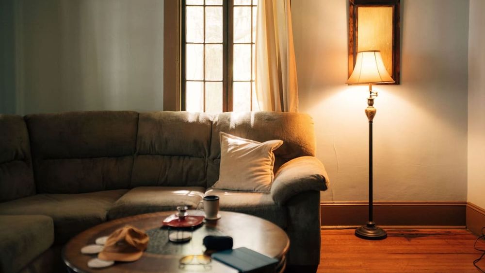 A warm, inviting living room interior featuring a sofa, coffee table, and floor lamp.