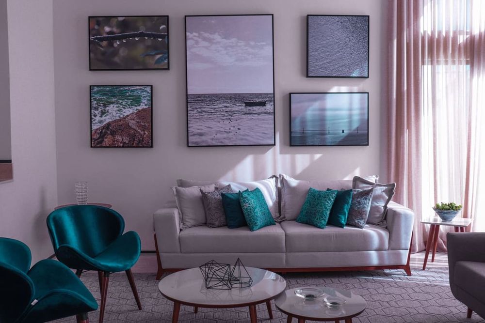 Contemporary living room featuring stylish decor, teal accents, and framed artwork.