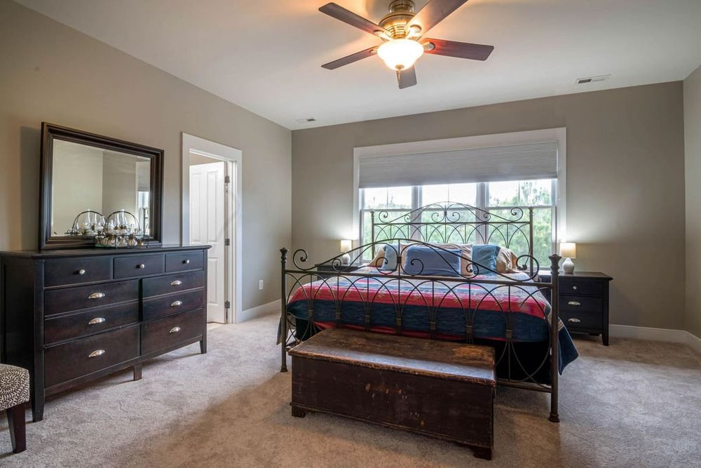 Spacious bedroom interior with double bed, elegant furniture, and natural light.