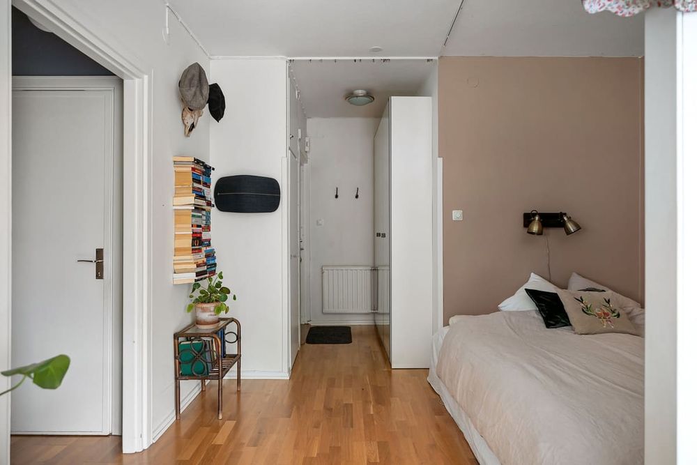 Stylish bedroom featuring a modern bookshelf, cozy bedding, and minimalist decor.