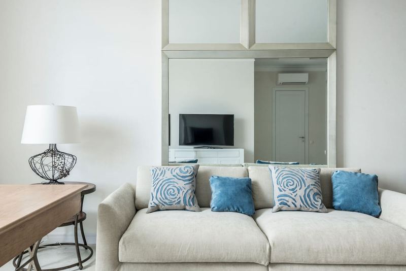 Interior of cozy living room with comfortable sofa with soft cushions placed near table with lamp