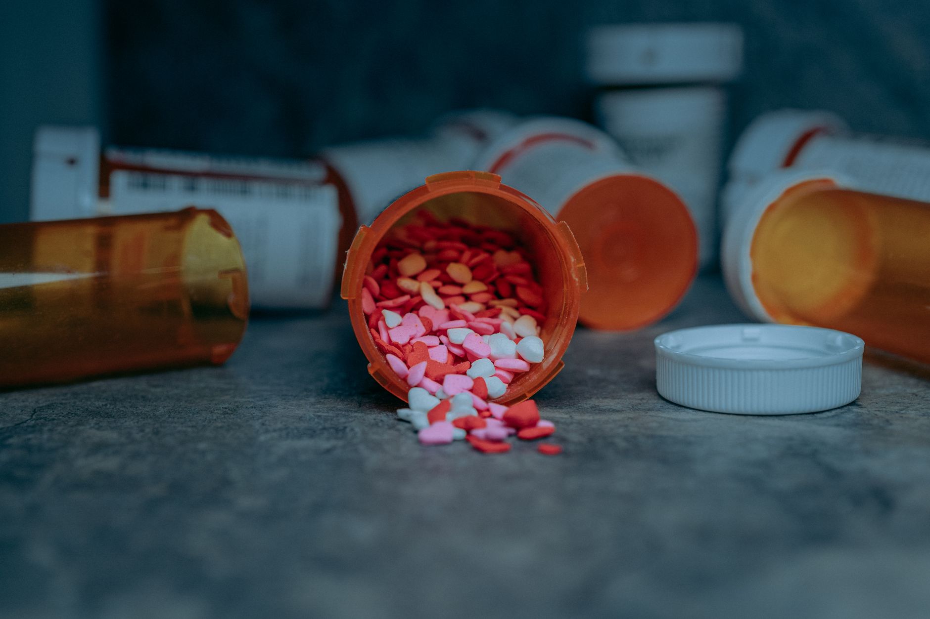 Colorful pills spilling from a prescription bottle on a counter