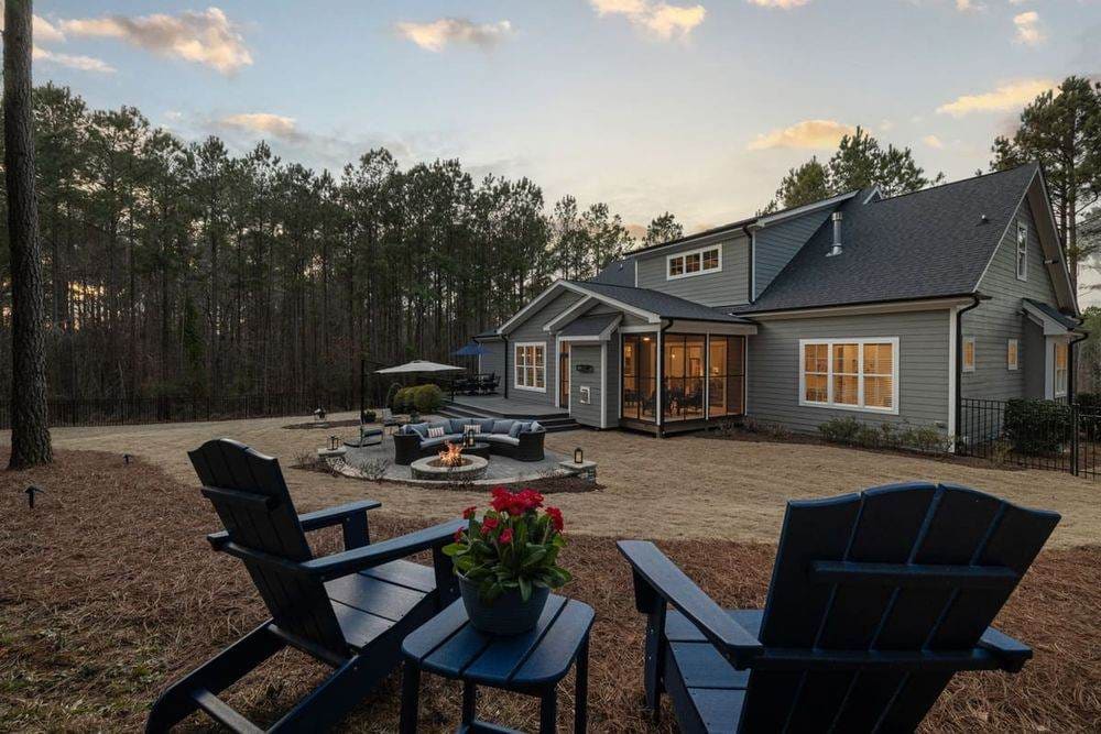 Beautiful backyard scene with fire pit, seating area, and Adirondack chairs at sunset.
