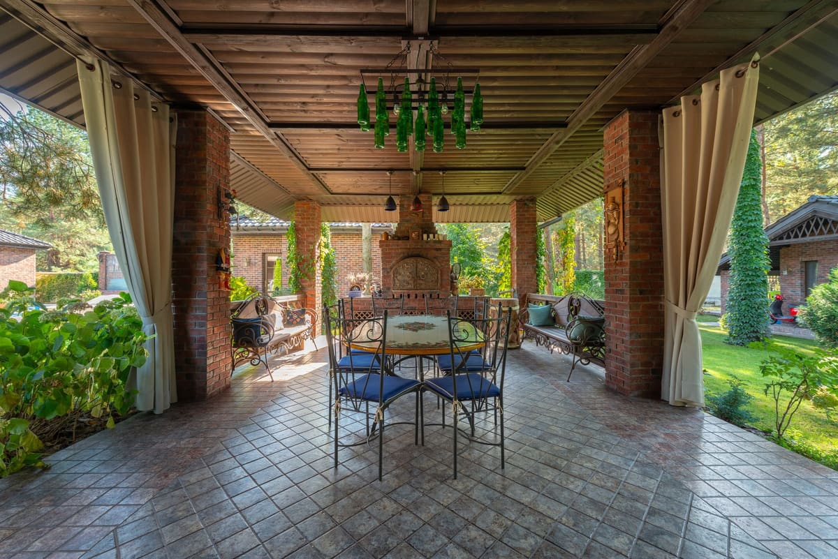 Charming patio with wrought iron furniture, brick walls, and garden views.
