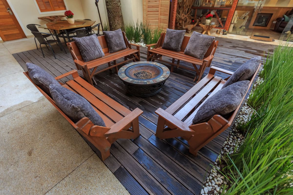 Inviting outdoor lounge with wooden benches and a central fire pit.