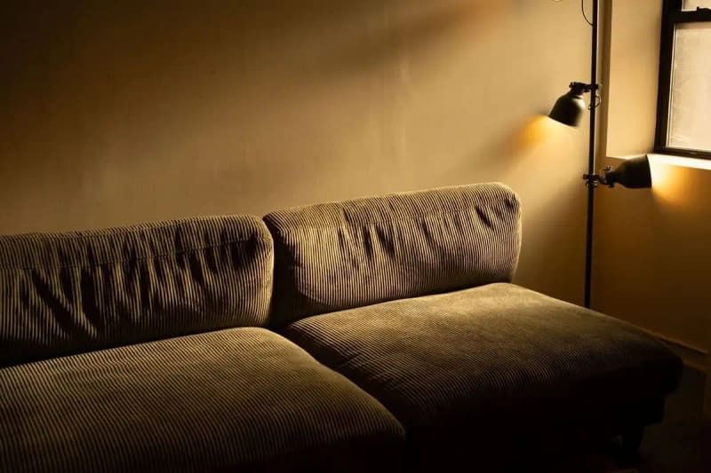 A corduroy sofa in a dimly lit room with a warm and inviting atmosphere.