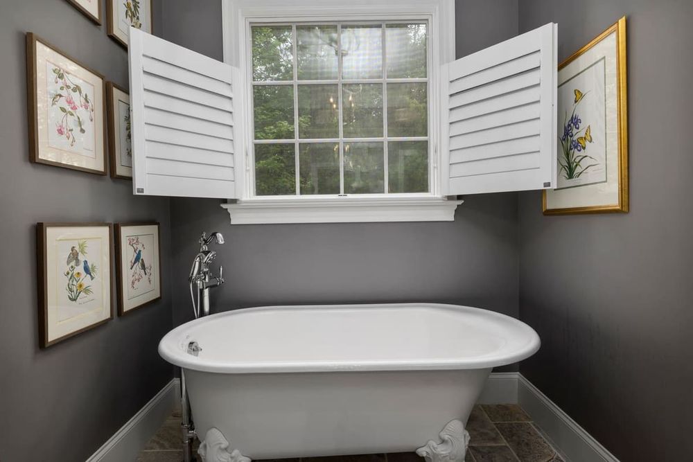 An elegant home interior featuring a classic freestanding bathtub and decorative wall art.