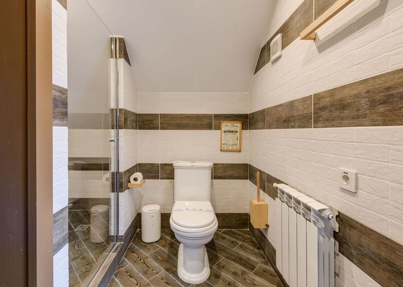 Minimalistic bathroom with clean white tiles and modern fixtures.