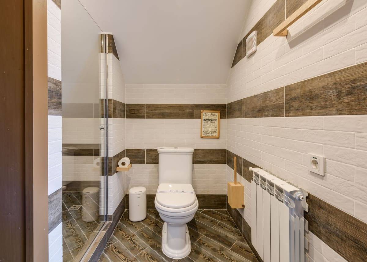 Minimalistic bathroom with clean white tiles and modern fixtures.