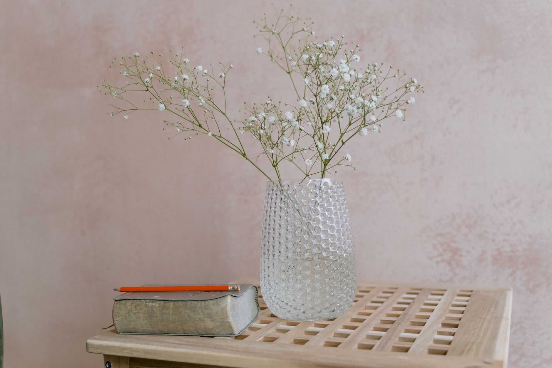 Stylish glass vase with gypsophila on a wooden table, perfect for minimal home decor inspiration.