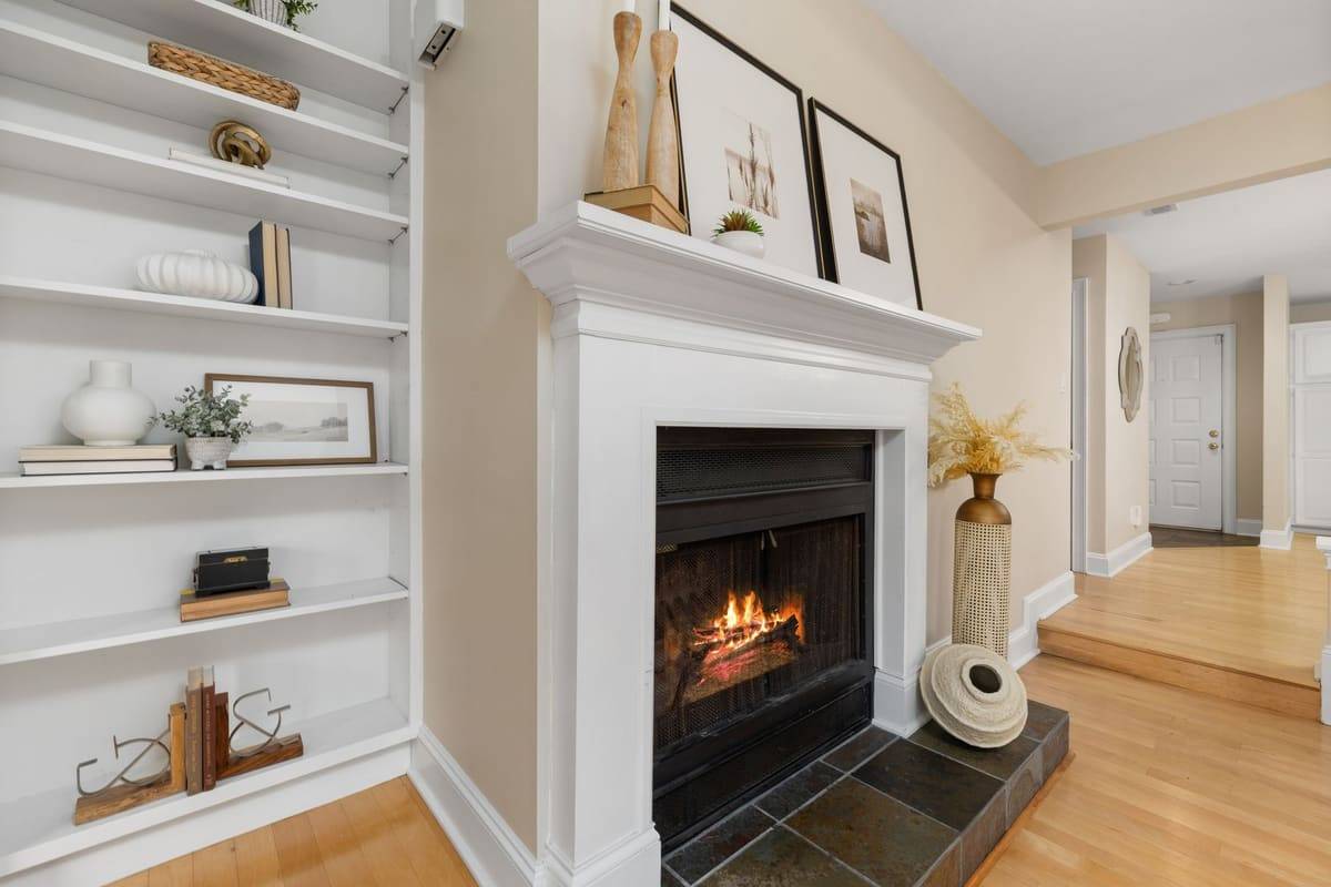 Elegant living room interior featuring a lit fireplace and decorative shelving.